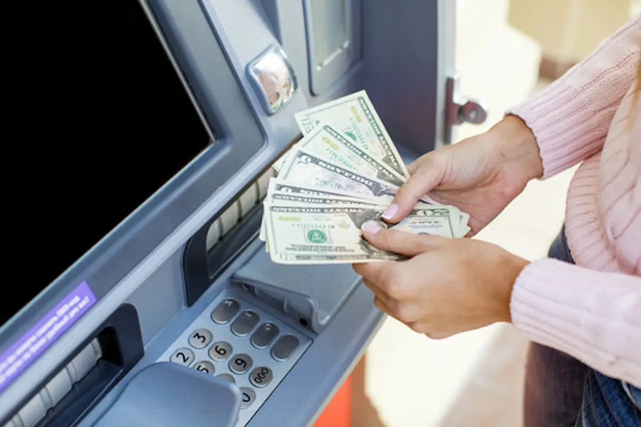 Customer receiving cash from ATM machine
