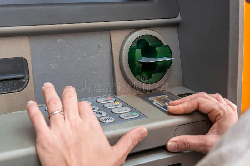 Close-up of secure ATM card insertion and cash dispensing transaction